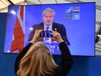 A journalist takes a picture of a television screen as Britain's Prime Minister Boris Johnson speaks during a press conference at the NATO summit at the Grove hotel in Watford, northeast of London on December 4, 2019. DANIEL LEAL-OLIVAS / AFP