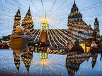 A man photographs the cathedral and the festive lighting of the Christmas market as they mirror on a polished surface in Mainz, Germany, on December 6, 2019.  Frank Rumpenhorst / dpa / AFP