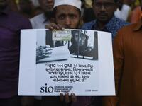 A Muslim man holds a placard as he participates along with others in a peaceful protest against the Citizenship Amendment Bill (CAB) and the National Register of Citizens (NRC) in Ahmedabad on December 15, 2019. Some 5,000 people took part in a fresh demonstration in Guwahati on December 15, with hundreds of police watching on as they sang, chanted and carried banners with the words "long live Assam". SAM PANTHAKY / AFP