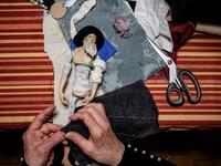 Volunteer Maria Franca Testa sews clothes for a nativity figure at the 43rd edition of the "Presepio of Cavallermaggiore", a 300sqm Christmas Nativity crib in the Oratorio San Michele on December 20, 2019 in Cavallermaggiore, near Cuneo, Northwestern Italy. The "presepio" is made by ten volunteers than every year spend 3 months to build a new edition with hundred of figures. MARCO BERTORELLO / AFP