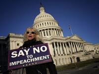 A woman supporting U.S. President Donald Trump walks outside the U.S. Capitol December 18, 2019 in Washington, DC. Later today the U.S. House of Representatives is expected to vote on two articles of impeachment against Trump charging him with abuse of power and obstruction of Congress. Win McNamee/Getty Images/AFP