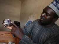 Ayuba Ahmad Muhammed, secretary of the Zamfara State Gold Buyers and Sellers, displays a mined mineral in Gusau, on December 5, 2019. For generations, the mineral-rich earth of Nigeria's Zamfara state has provided families living here with a way to make ends meet. Kola Sulaimon / AFP
