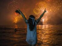 A woman celebrates as she watches the traditional New Year's fireworks at Copacabana Beach in Rio de Janeiro, Brazil, on December 31, 2019. DANIEL RAMALHO / AFP