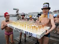 Participants celebrate during a New Year's traditional bathe at Lake Geneva in Geneva on January 1, 2020, where some 70 swimmers braved the 7degree celsius waters of the lake to take part in the event. FABRICE COFFRINI / AFP