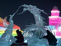 Ice sculptors give finishing touches on an ice sculpture ahead of the opening of the Harbin International Ice and Snow Festival in Harbin, in China's northeast Heilongjiang province on January 3, 2020. NOEL CELIS / AFP
