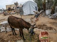 Palestinian Hammouda Abu Amra, 51, digs to divert water from entering his shack after heavy rains in Khan Yunis in the southern Gaza Strip on January 10, 2020. Abu Amra, whose house was destroyed by an Israeli air strike last November, now lives in a shack with his family of seventeen. SAID KHATIB / AFP