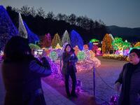 In a photo taken on January 11, 2020 visitors look at an annual light display at the 'Garden on Morning Calm', near Gapyeong, east of Seoul. Ed JONES / AFP