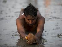 A Hindu devotee performs a ritual before taking a holy dip in the Bay of Bengal during the Gangasagar Mela, at Sagar Island, around 150 kms south of Kolkata on January 13, 2020. XAVIER GALIANA / AFP