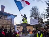 Masked revellers - one wearing a yellow vest waving a French national flag - another with a placard which reads as " enough is enough" take part with others in a carnival procession through the south-western North Macedonian village of Vevcani, on January 13, 2020. The Vevcani carnival is 1.400 years old and is held every year on the eve of the feast of Saint Basil (January 14), which also marks the beginning of the New Year according to the Julian calendar, observed by the Macedonian Orthodox Church. Rober