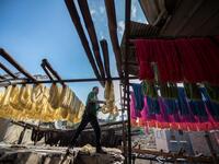 Mohamed Kamal, a 59-year-old dye worker, hangs dyed yarns out to dry in the sun at a traditional hand-dying workshop in the Egyptian capital Cairo's centuries old district of Darb al-Ahmar on January 21, 2020. Khaled DESOUKI / AFP