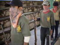 Children line up as thay are tought to use weapons by the Regional Coordinator of Community Authorities (CRAC-PF) community police force at a basketball court in the village of Ayahualtempan, Guerrero State, Mexico, on January 24, 2020. The CRAC-PF vigilante group trains children as young as five so they can protect themselves from drug-related criminal groups operating in the area. Pedro PARDO / AFP