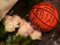 A basketball with the words "KB & 24 Forever" written on it and white roses are placed at a makeshift memorial as fans gather to the mourn the death of NBA legend Kobe Bryant, who was killed along with his daughter and seven others in a helicopter crash on January 26, at LA Live plaza in front of Staples Center in Los Angeles on January 27, 2020. Federal investigators sifted through the wreckage of the helicopter crash that killed basketball legend Kobe Bryant and eight other people, hoping to find clues to
