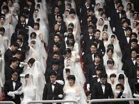 Couples attend a mass wedding ceremony organised by the Unification Church at Cheongshim Peace World Center in Gapyeong on February 7, 2020. Thousands of Unification Church couples married at a mass wedding to mark the eighth anniversary of the death of founder and self-proclaimed messiah Sun Myung Moon. Jung Yeon-je / AFP