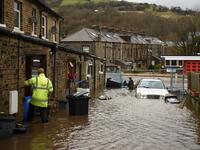 A man enters a house on a flooded street in Mytholmroyd, northern England, on February 9, 2020, after the River Calder burst its banks as Storm Ciara swept over the country. Britain and Ireland hunkered down Sunday for a powerful storm expected to disrupt air, rail and sea links, cancel sports events, cut electrical power and damage property. With howling winds and driving rain, forecasters said Ciara would also hit France, Belgium, the Netherlands, Switzerland and Germany. Oli SCARFF / AFP