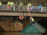 Workers secure a shipping container, lodged under the Rastrick Bridge, after it floated down the River Calder in Brighouse, northern England, on February 10, 2020 after the flooding brought on by Storm Ciara. Storm Ciara grounded hundreds of flights Monday and left swatches of Europe without power after unleashing torrential rain and causing flash flooding that cancelled football matches in Britain. Oli SCARFF / AFP