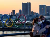 People wear face masks as they take pictures in front of the Olympic Rings at the Odaiba Seaside Park in Tokyo on March 6, 2020. Construction of all new permanent venues for the Tokyo 2020 Olympics and Paralympics is now complete, organisers said on March 6, as preparations continue despite worries over the new coronavirus outbreak. Philip FONG / AFP
