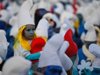A child dressed as Smurfs ('Schtroumpfs' in French), a Belgian comic franchise centered on a fictional colony of small, blue, human-like creatures who live in mushroom-shaped houses in the forest, sits on the shoulders of an adult during a world record gathering of Smurfs on March 7, 2020, in Landerneau, western France. Damien MEYER / AFP