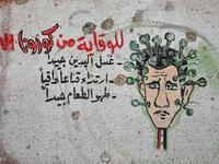 A graffiti portraying President Bashar al-Assad as the coronavirus is seen on the wall of a destroyed school in Binnish town in Syria’s northwestern Idlib province near the Turkish border, on March 10, 2020. Ozan KOSE / AFP