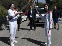 European Commission vice-president in charge for promoting our European way of life Margaritis Schinas (L) holds the Olympic flame during the flame lighting ceremony on March 12, 2020 in ancient Olympia, ahead of the Tokyo 2020 Olympic Games. LOUISA GOULIAMAKI / AFP
