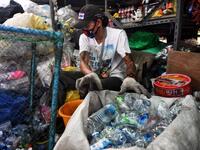 A Buddhist devotee sorts salvaged plastic bottles to be recycled into monks’ robes and face masks, amid concerns over the spread of the COVID-19 coronavirus, at Wat Chak Daeng Buddhist temple in Samut Prakan on March 23, 2020. The plastic wastes are sent to a separate recycling facility processing it into thread materials and woven as special fabric for monks. Lillian SUWANRUMPHA / AFP