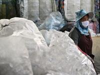 A Buddhist devotee sorts salvaged plastic bottles to be recycled into monks’ robes and face masks, amid concerns over the spread of the COVID-19 coronavirus, at Wat Chak Daeng Buddhist temple in Samut Prakan on March 23, 2020. The plastic wastes are sent to a separate recycling facility processing it into thread materials and woven as special fabric for monks. Lillian SUWANRUMPHA / AFP