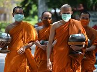 Buddhist monks (back) wear face masks made from recycled plastic bottles, amid concerns over the spread of the COVID-19 coronavirus, at Wat Chak Daeng Buddhist temple in Samut Prakan on March 23, 2020. The plastic wastes are sent to a separate recycling facility processing it into thread materials and woven as special fabric for monks. Lillian SUWANRUMPHA / AFP