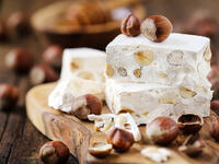Delicious Italian festive torrone or nougat with hazelnuts on a wood (Shutterstock)