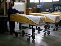 An employee covers coffins at the Eurocoffin coffins factory in Barcelona on April 3, 2020. More than 900 people died in Spain over the past 24 hours for the second day running, government figures showed, although the rate of new infections and deaths continued to slow. Spain has the world's second-highest death toll after Italy with the virus so far claiming 10,935 lives from 117,710 confirmed cases.  PAU BARRENA / AFP