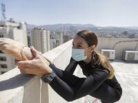 Sherazade Mami, a 28-year-old Tunisian professional dancer and performer at the Caracalla dance theatre and a teacher at the Caracalla dance school, practices while wearing a surgical mask on the roof of her apartment building in the suburb of Dekwaneh on the eastern outskirts of Lebanon's capital Beirut on April 4, 2020. Due to the confinement regulations imposed to combat the COVID-19 coronavirus pandemic, Mami opted to continue practicing on her rooftop to remain in shape. JOSEPH EID / AFP