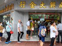 People wearing face masks amid fears of the spread of COVID-19 coronavirus line up to sell their jewelries in front of a gold shop in Bangkok's Chinatown on April 15, 2020. Hundreds of Bangkok residents rushed to goldsmith shops in order to sell their jewelries as gold prices reached its highest levels since 2012. Mladen ANTONOV / AFP