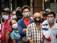 People wearing face masks amid fears of the spread of COVID-19 coronavirus line up to sell their jewelries in front of a gold shop in Bangkok's Chinatown on April 15, 2020. Hundreds of Bangkok residents rushed to goldsmith shops in order to sell their jewelries as gold prices reached its highest levels since 2012. Mladen ANTONOV / AFP