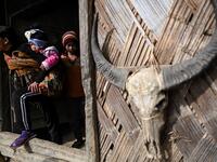 This photo taken on February 9, 2020 shows people leaving a Union Solidarity and Development Party house in Karmawlawyi village in Myanmar's Sagaing region, near the border with India. The king of the Konyak tribe sleeps in Myanmar, but eats in India -- his house, village and people divided by a mountain border which serves as a vulnerable lifeline now severed by a coronavirus lockdown.  Ye Aung THU / AFP