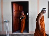 Novice monks wearing face shields as a preventive measure against the spread of the COVID-19 coronavirus leave the classroom after religious studies at Wat Molilokkayaram Buddhist temple in Bangkok on April 20, 2020. Lillian SUWANRUMPHA / AFP