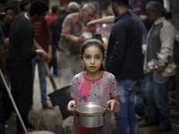 A Palestinian girl carries a portion of soup, given out to poor families, during the Islamic holy month of Ramadan in Gaza City on April 24, 2020, amid the COVID-19 coronavirus pandemic. Mohammed ABED / AFP