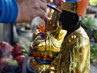 In this picture taken on March 17, 2020, sculptor Lin Hsin-lai paints a Taoist god statue during a ceremony at his workplace in Taoyuan, northern Taiwan. Every spare surface of Lin Hsin-lai's four-storey shop is crammed with a pantheon of Taiwan's celestial beings, testament to the decades he has spent sheltering and restoring unwanted statues of gods.  Sam Yeh / AFP