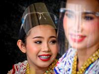 Traditional Thai dancers wearing protective face shields relax after a performance at the Erawan Shrine, which was reopened after the Thai government relaxed measures to combat the spread of the COVID-19 novel coronavirus, in Bangkok on May 4, 2020. Thailand began easing restrictions related to the COVID-19 novel coronavirus on May 3 by allowing various businesses to reopen, but warned that the stricter measures would be re-imposed should cases increase again. Mladen ANTONOV / AFP