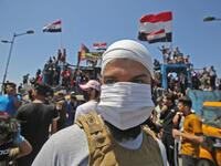 An Iraqi protester wears a face mask during an anti-government demonstration on Al-Jumhuriyah bridge in the capital Baghdad, on May 10,2020. Modest anti-government rallies resumed in some Iraqi cities today, clashing with security forces and ending months of relative calm just days after Prime Minister Mustafa Kadhemi's government came to power. AHMAD AL-RUBAYE / AFP