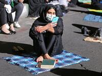 An Iranian woman wearing a face mask against the Covid-19 coronavirus attends Laylat al-Qadr prayers, one of the holiest nights during the Muslim fasting month of Ramadan, outside a mosque in the Tehran, on May 13, 2020. ATTA KENARE / AFP