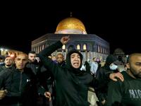 Palestinian men react as they walk in front of the Dome of Rock at the Al-Aqsa Mosque compound, before the start of the dawn prayer (salat al-fajr) inside the compound in Jerusalem's Old City, on May 31, 2020, after a two-month closure due to the COVID-19 pandemic. AHMAD GHARABLI / AFP