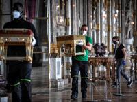 A worker carries furniture in the Galerie des Glaces (Hall of Mirrors) at the Chateau de Versailles (Palace of Versailles) in Versailles near Paris, on June 5, 2020, on the eve of it re-opening after 82 days of closure due to the novel coronavirus (COVID-19) outbreak. The Palace of Versailles -- France's big tourist attraction with nearly 10 million tourists a year - will open on June 6 with no US or Asia tourists who represent 30% of its visitors. STEPHANE DE SAKUTIN / AFP