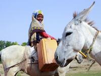 A Yemeni girl riding a donkey waits to fill jerrycans with water from a cistern at a make-shift camp for the internally displaced, in the northern Hajjah province, on June 7, 2020, amid a severe shortage of water. ESSA AHMED / AFP