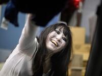 This picture taken on June 15, 2020 shows actress Haruna Suzuki, 20, cleaning up fake blood from the window of a car following a demonstration of a drive-in haunted house at a garage in Tokyo. A car horn beeps and the horror begins: a bloody murder and rampaging zombies. But this drive-in haunted house in Japan protects against the most terrifying enemy of all -- coronavirus. Inside a car, guests can scream as loudly as they like, with no mask required, as hideous creatures daubed in blood swarm towards the