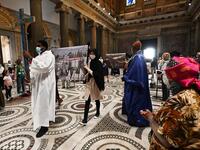 Priests and faithful, wearing protective face masks over their traditional dress and respecting security distances, attend a vigil prayer for the deceased would be migrants as part of the International Migrants Day, in Rome's Basilica of Our Lady in Trastevere neighbourhood on June 18, 2020. The Community of Sant'Egidio organised a prayer for all 2039 people died in the Mediterranean during the 2019, speaking if even their name is today unknown to men, they are in the heart of God. Vincenzo PINTO / AFP