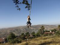A girl swings at a park in the Israeli Yitzhar settlement south of the Palestinian city of Nablus in the occupied the West Bank on June 22, 2020. The government of Israeli Prime Minister Benjamin Netanyahu has said it could begin the process to annex Jewish settlements in the West Bank as well as the strategic Jordan Valley from July 1.The plan -- endorsed by Washington -- would see the creation of a Palestinian state, but on reduced territory, and without Palestinians' core demand of a capital in east Jeru