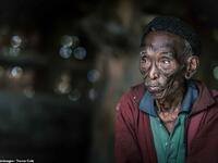 A frail-looking tribesman wears green shirt and red jacket with a black wool hat in what appears to be a merging of traditional culture with more western fashion trends. (Mediadrumimages/ Trevor Cole)