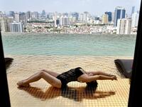 A guest poses for photographs at the infinity pool of the newly-inaugurated Dolce Hanoi Golden Lake hotel, the world's first gold-plated hotel, in Hanoi on July 2, 2020. Manan VATSYAYANA / AFP