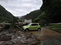 A car is seen among debris littering a village following heavy rains and flooding in the village of Takayama, Gifu prefecture on July 9, 2020. Japanese emergency services and troops were scrambling to reach thousands of homes cut off by devastating flooding and landslides that have killed dozens and caused widespread damage. Philip FONG / AFP