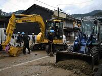 Workers clear debris and mud outside homes following heavy rains and flooding in the village of Gero, Gifu prefecture on July 9, 2020. Japanese emergency services and troops were scrambling to reach thousands of homes cut off by devastating flooding and landslides that have killed dozens and caused widespread damage. Philip FONG / AFP
