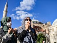 Women pray outside the Hagia Sophia museum on July 10, 2020 in Istanbul as people gather to celebrate after a top Turkish court revoked the sixth-century Hagia Sophia's status as a museum, clearing the way for it to be turned back into a mosque. The Council of State, the country's highest administrative court which on July 2 debated a case brought by a Turkish NGO, cancelled a 1934 cabinet decision and ruled the UNESCO World Heritage site would be reopened to Muslim worshipping. The sixth-century Istanbul b