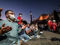 People, some wearing face masks, pray outside the Hagia Sophia museum in Istanbul on July 10, 2020 as they gather to celebrate after a top Turkish court revoked the sixth-century Hagia Sophia's status as a museum, clearing the way for it to be turned back into a mosque. The Council of State, the country's highest administrative court which on July 2 debated a case brought by a Turkish NGO, cancelled a 1934 cabinet decision and ruled the UNESCO World Heritage site would be reopened to Muslim worshipping. The